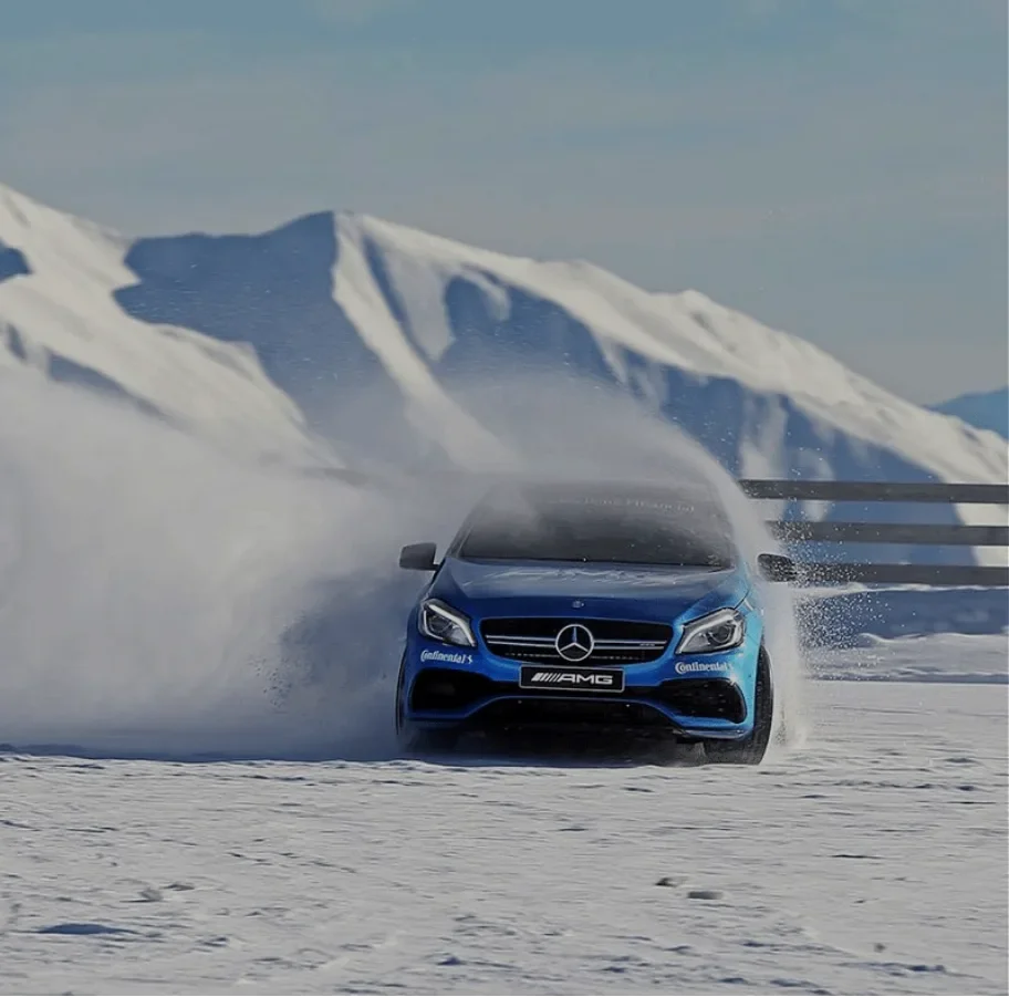 A Mercedes-AMG drifting across a snowfield.