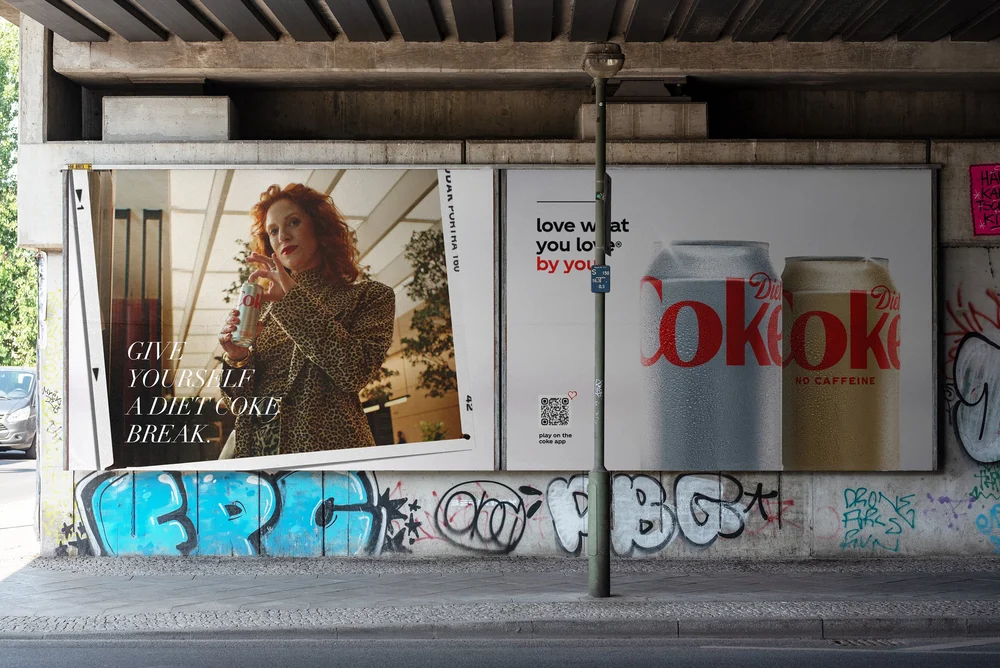 Diet Coke 48-sheet under a railway bridge showing a woman in a leopard-print coat and the headline Give yourself a Diet Coke break.