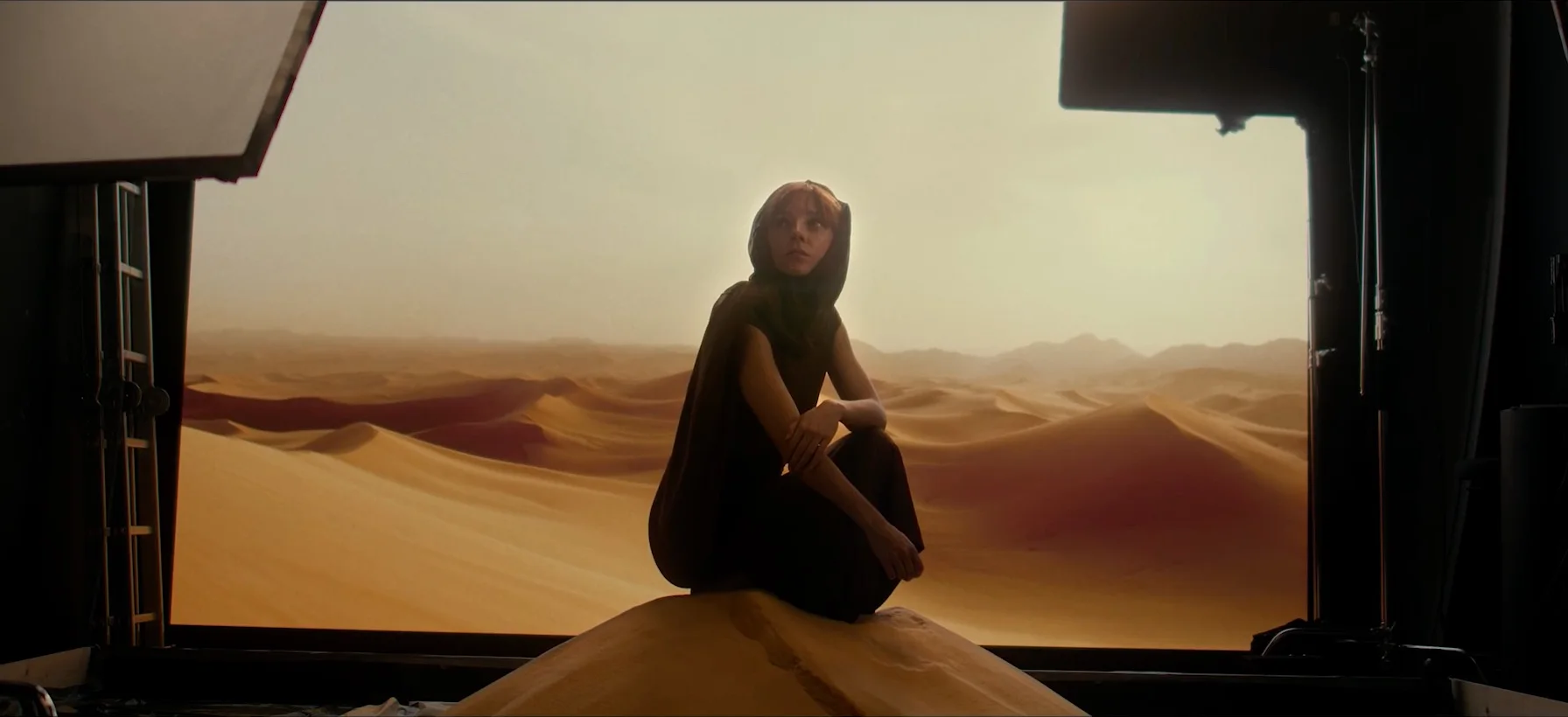 Demo film still shot in the virtual studio: a woman sitting on a desert dune.